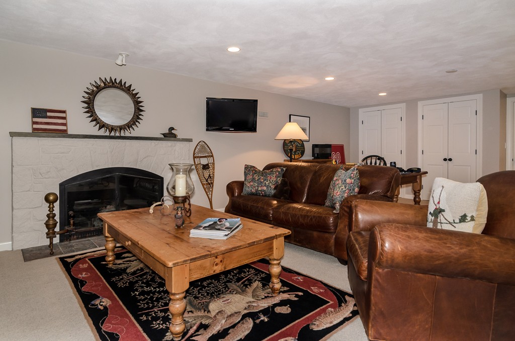21 Carisbrooke Road Wellesley, MA 02481 - Photo 17 of 18 a living room with furniture a fireplace and a flat screen tv