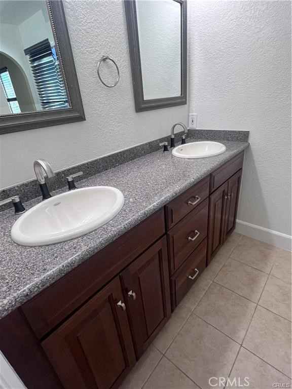 21681 Cabrosa Mission Viejo, CA 92691 - Photo 16 of 22 a bathroom with a granite countertop sink a mirror and a vanity