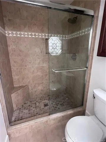 a bathroom with a toilet and a shower