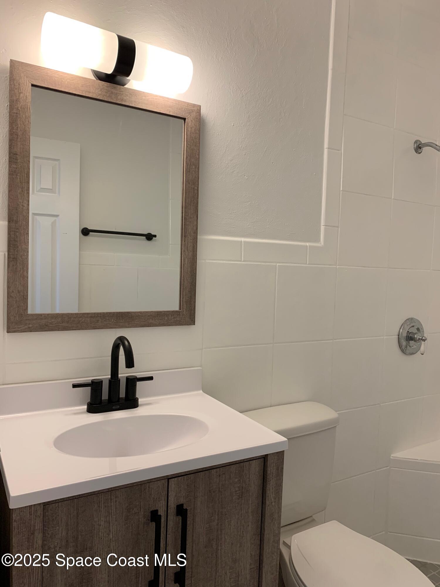 110 Del Flora Indialantic, FL 32903 - Photo 17 of 33 a bathroom with a sink a toilet and mirror