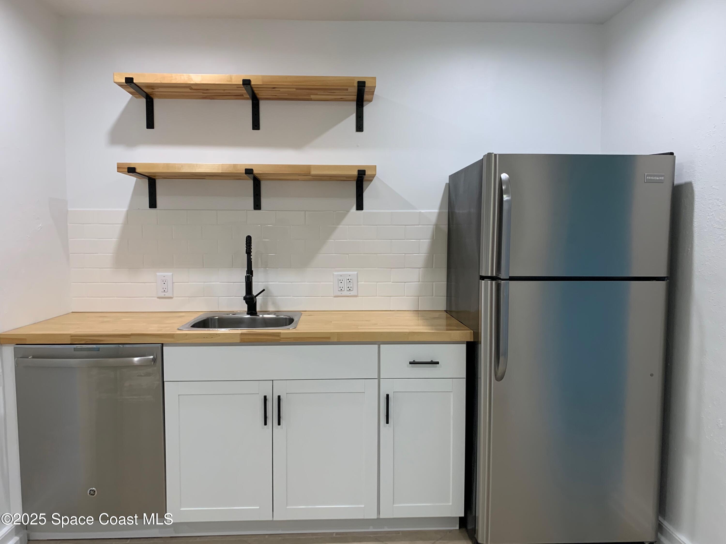 110 Del Flora Indialantic, FL 32903 - Photo 5 of 33 a kitchen with a refrigerator and cabinets
