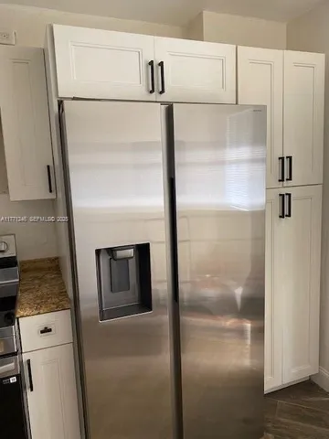 a close view of a refrigerator in kitchen and stainless steel appliances wooden floor