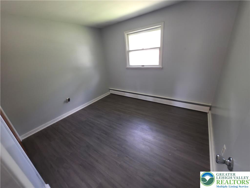 719 Keystone Avenue Bethlehem, PA 18018 - Photo 16 of 32 A well-lit bedroom with fresh dark wood-look flooring and a bright window.