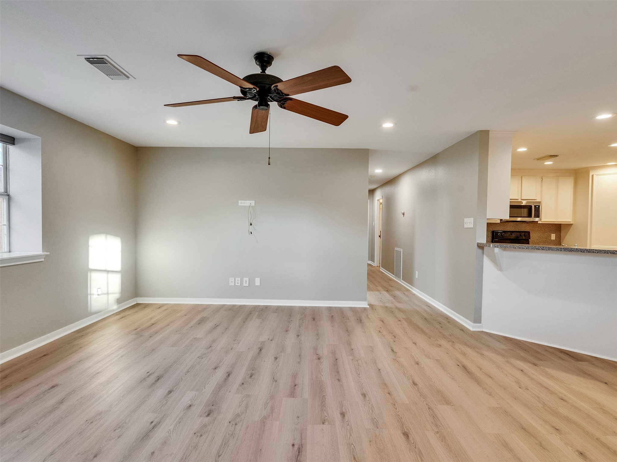 7301 Pearson Road Santa Fe, TX 77517 - Photo 15 of 46 a view of a big room with wooden floor a ceiling fan and windows