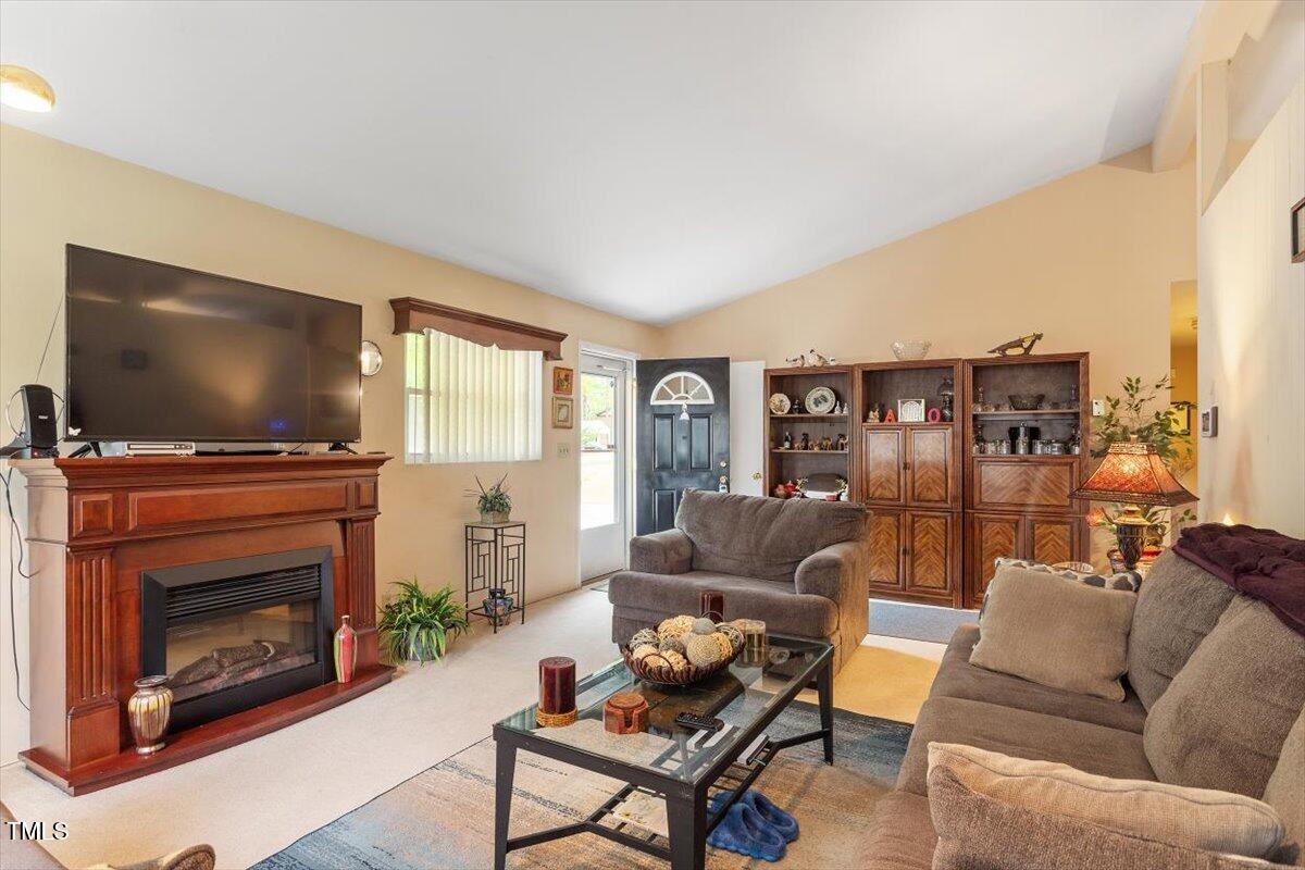 911 Williams Road Raleigh, NC 27610 - Photo 14 of 33 a living room with furniture a flat screen tv and a fireplace