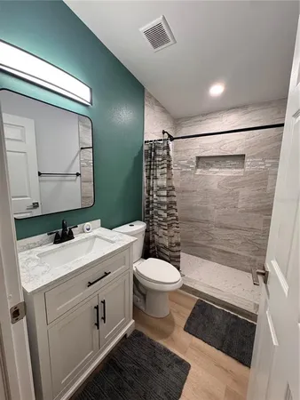 a bathroom with a sink toilet and shower