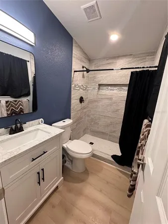 a bathroom with a sink a toilet and shower