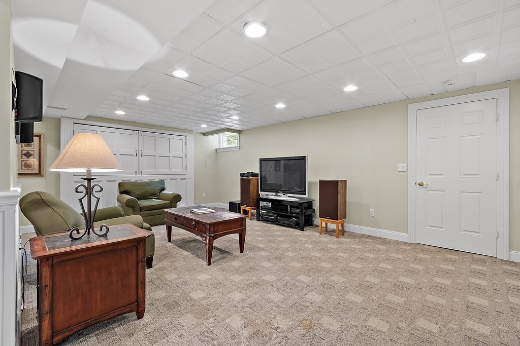 106 Fox Run Road Bolton, MA 01740 - Photo 36 of 41 a living room with furniture a flat screen tv and a refrigerator