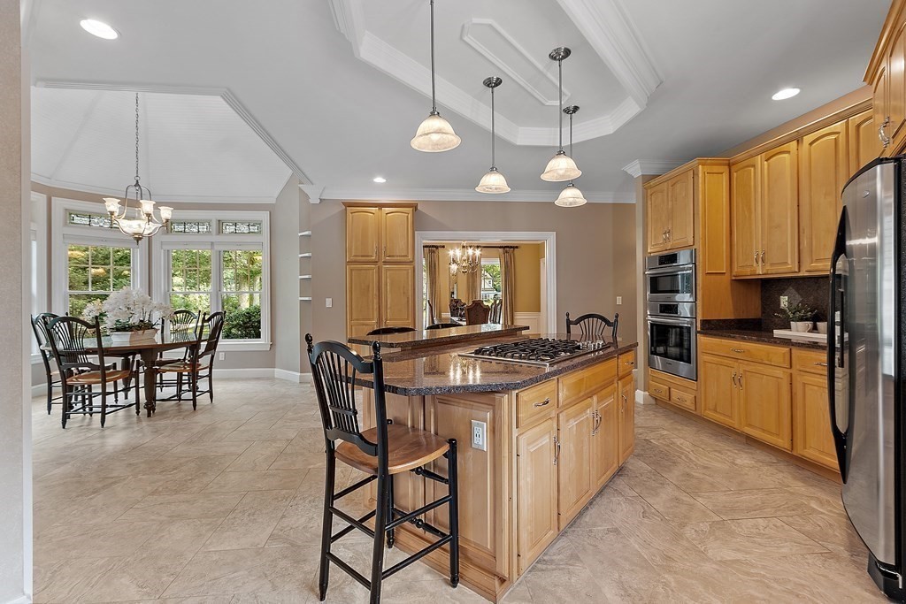 106 Fox Run Road Bolton, MA 01740 - Photo 5 of 41 a kitchen with stainless steel appliances granite countertop a stove a refrigerator a sink a dining table and chairs with white cabinets