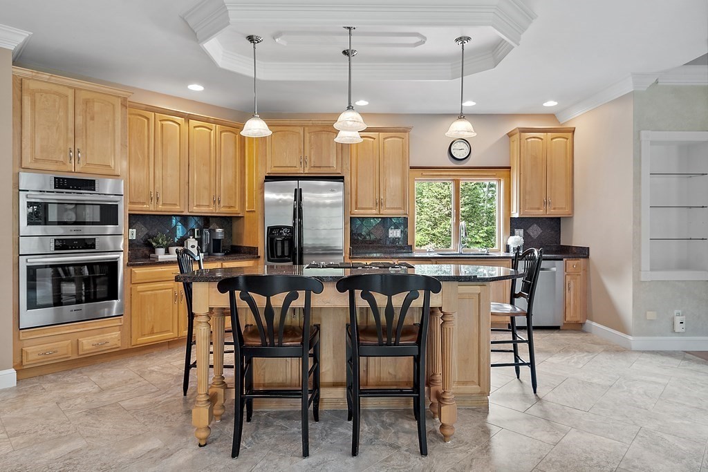 106 Fox Run Road Bolton, MA 01740 - Photo 7 of 41 a kitchen with stainless steel appliances granite countertop a stove top oven a refrigerator a sink with a dining table and chairs