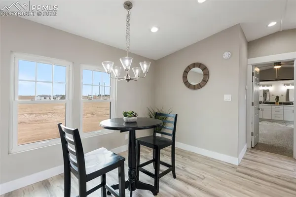a kitchen with a refrigerator and a wooden floor