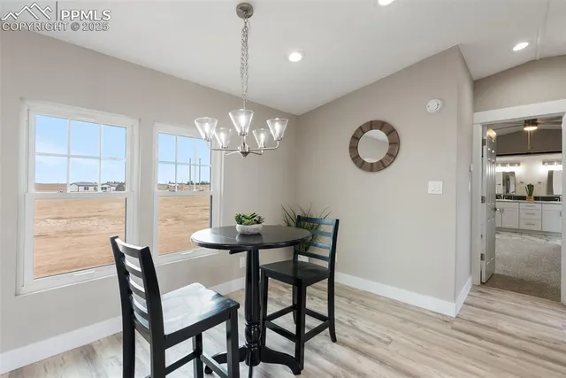 a kitchen with a refrigerator and a wooden floor