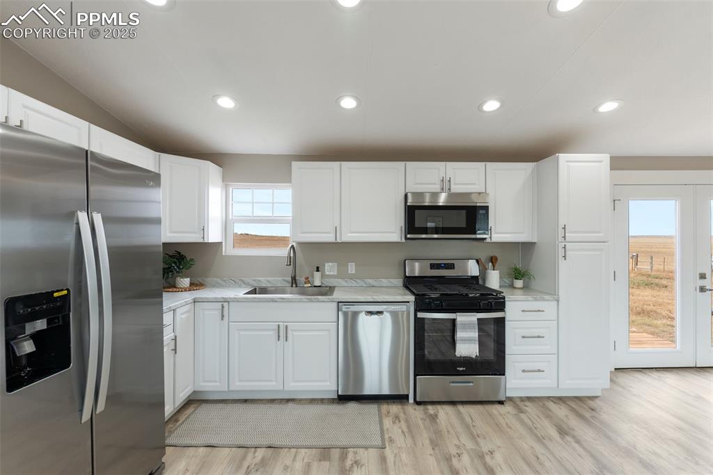 6190 Night Train Lane Yoder, CO 80864 - Photo 13 of 35 a kitchen with stainless steel appliances granite countertop a stove top oven a refrigerator and a sink