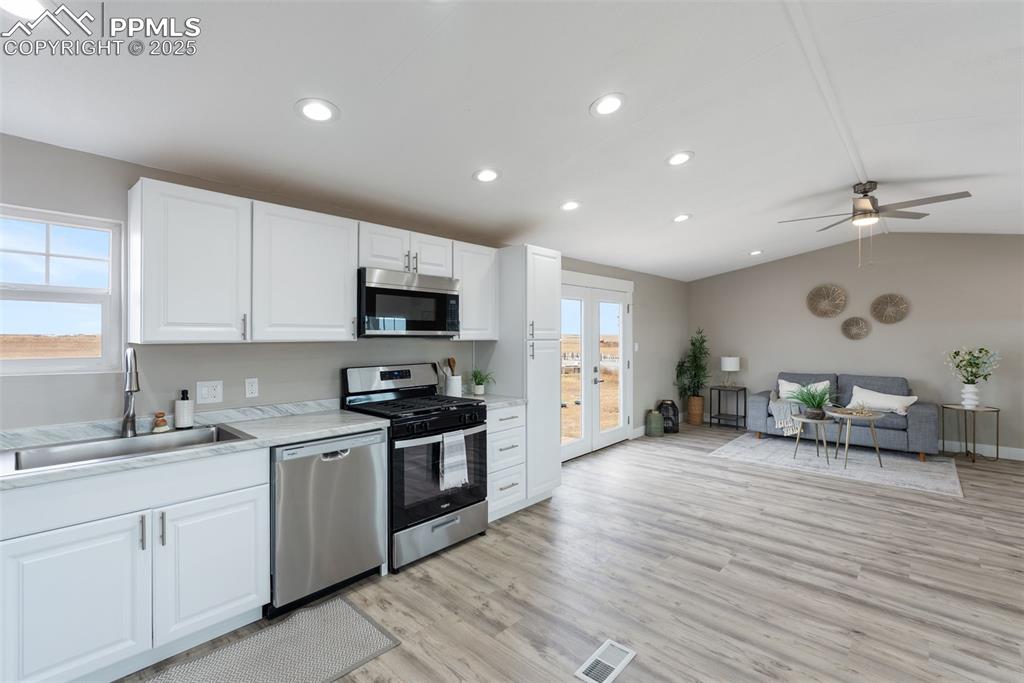 6190 Night Train Lane Yoder, CO 80864 - Photo 14 of 35 a kitchen with granite countertop a sink stainless steel appliances and cabinets