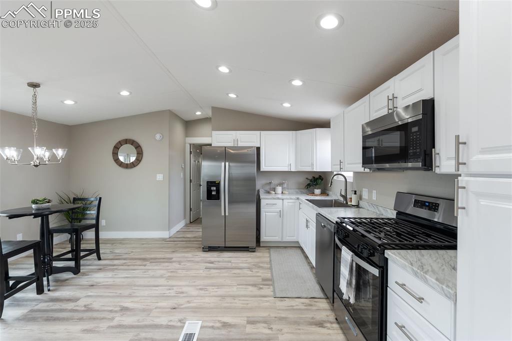 6190 Night Train Lane Yoder, CO 80864 - Photo 15 of 35 a kitchen with stainless steel appliances granite countertop a refrigerator stove microwave and sink