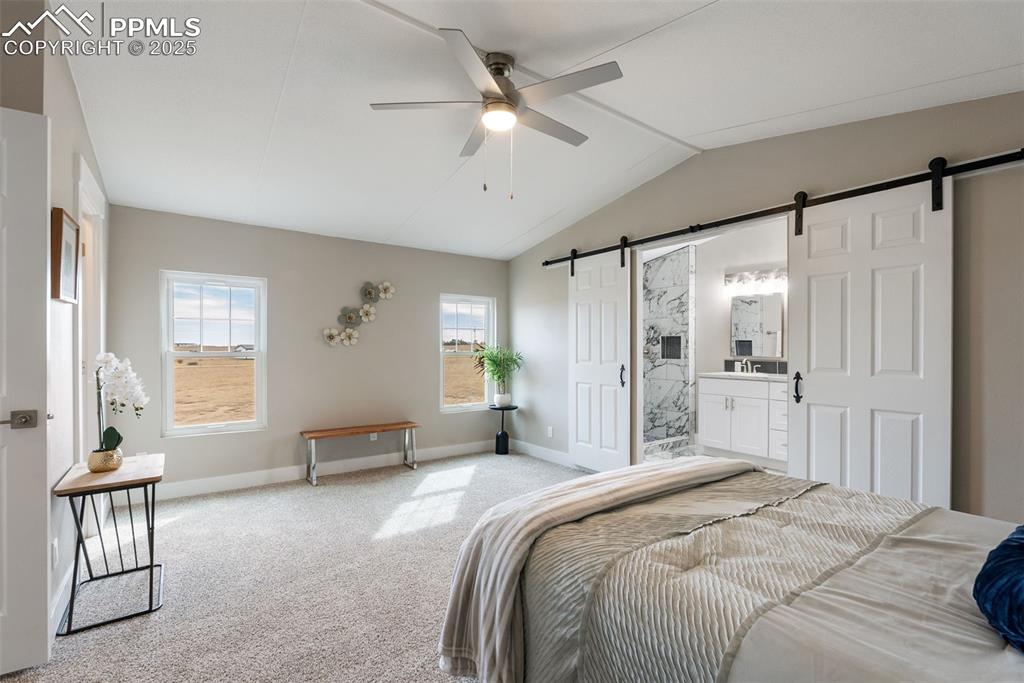 6190 Night Train Lane Yoder, CO 80864 - Photo 21 of 35 a spacious bedroom with a large bed a chandelier and windows