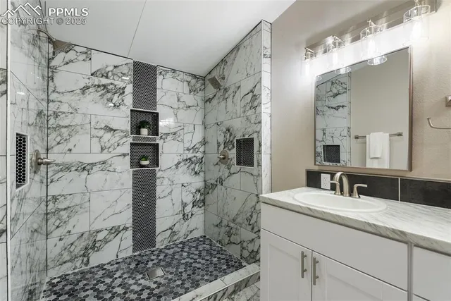 a bathroom with a granite countertop toilet sink and mirror