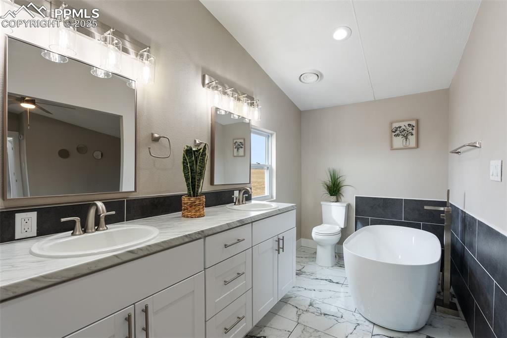 6190 Night Train Lane Yoder, CO 80864 - Photo 24 of 35 a bathroom with a granite countertop toilet sink and mirror
