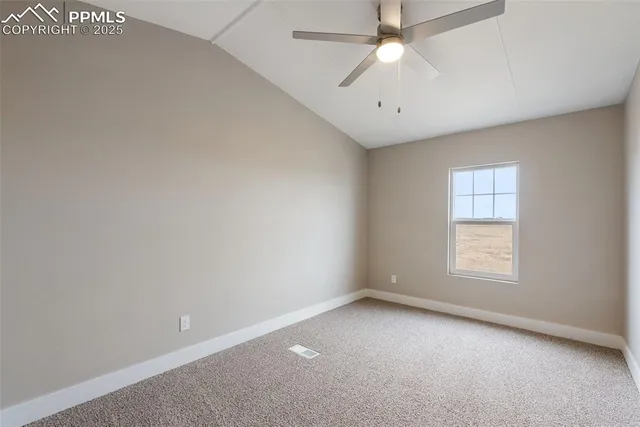 an empty room with a ceiling fan and a fan