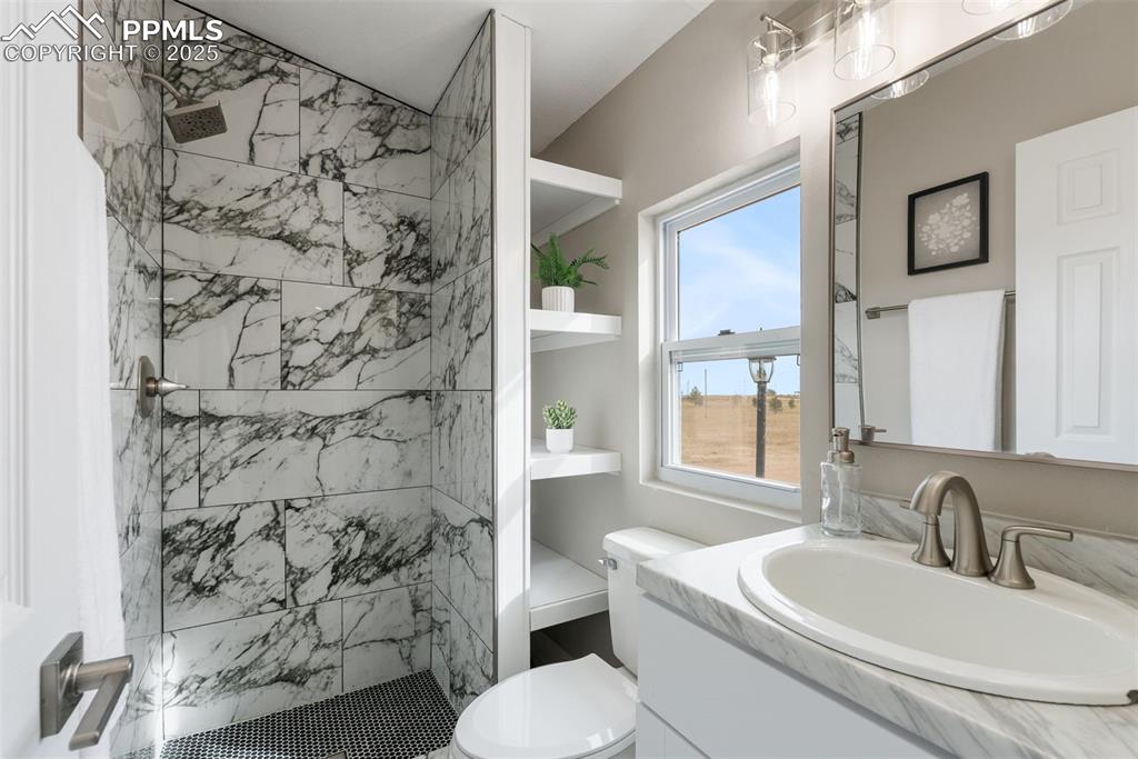 6190 Night Train Lane Yoder, CO 80864 - Photo 31 of 35 a bathroom with a sink toilet vanity and shower