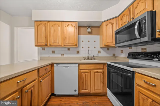 a kitchen with stainless steel appliances granite countertop a sink stove and microwave