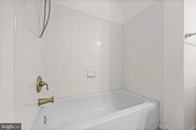 a white bath tub sitting next to a white sink and a shower