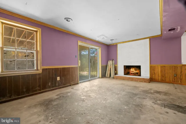 a view of an empty room with a fireplace and a window