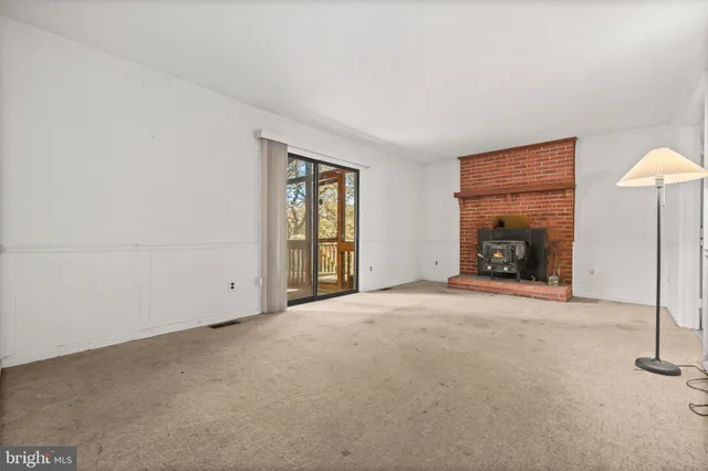 an empty room with windows and fireplace