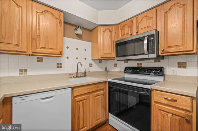 a kitchen with stainless steel appliances granite countertop white cabinets sink and a granite counter top