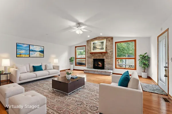 a living room with furniture large window and a fireplace