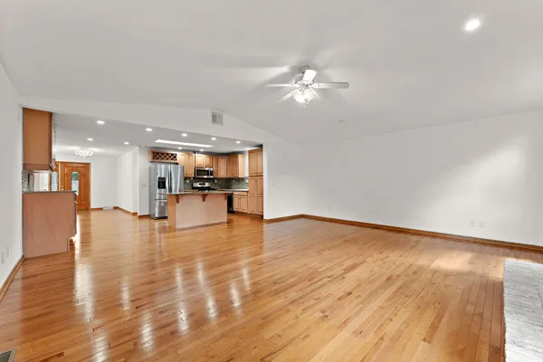 a view of an empty room kitchen and wooden floor