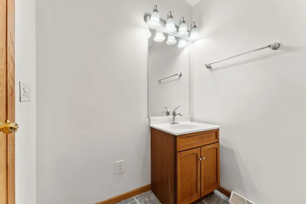 a bathroom with a sink a light fixture and a mirror