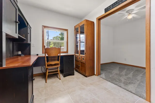 a view of a workspace with furniture and a window