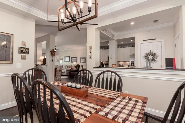 a kitchen with stainless steel appliances granite countertop a refrigerator a sink dishwasher a stove and white cabinets with wooden floor