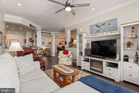 a living room with furniture a bookshelf and a window