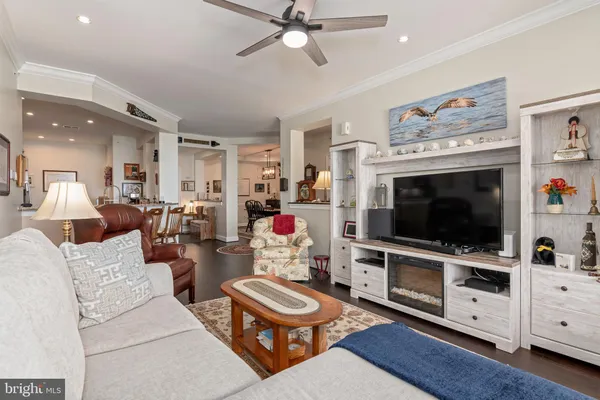 a living room with furniture a bookshelf and a window