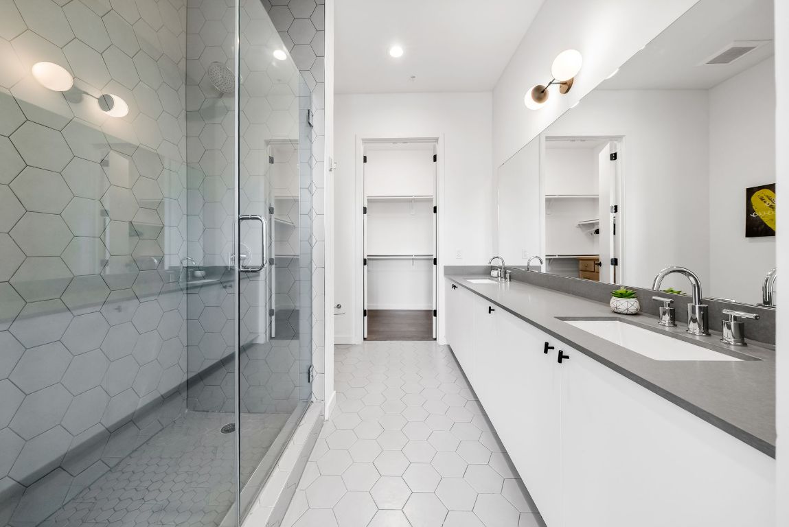 800 Embassy Drive, Unit 337 Austin, TX 78702 - Photo 11 of 29 a large bathroom with a double vanity sink a toilet and shower