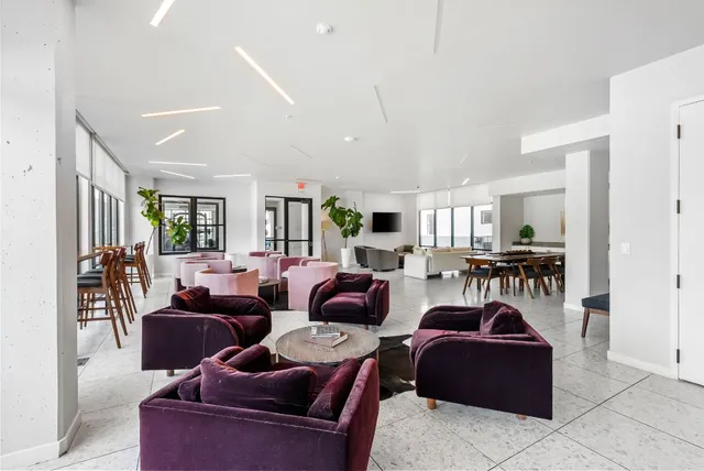 a living room with furniture a red lamp and a window