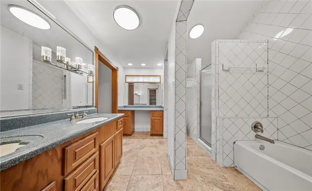 a spacious bathroom with a bathtub sink and mirror