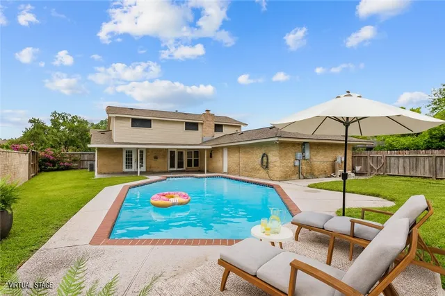 a view of a house with backyard sitting area and garden