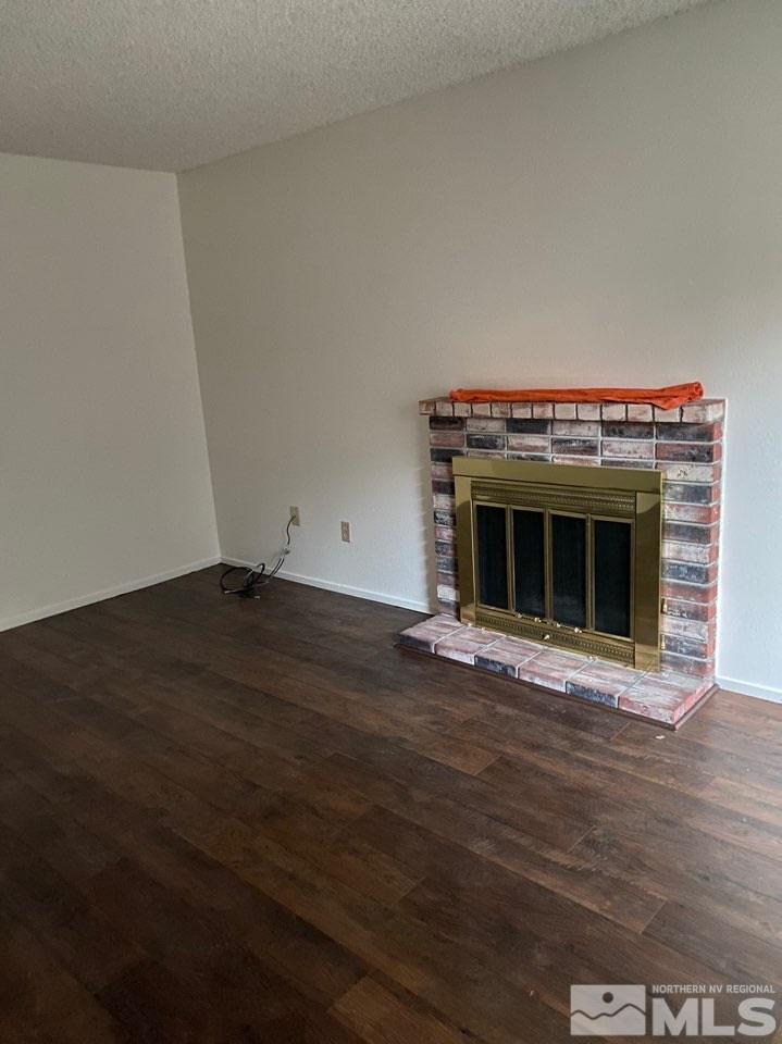 4597 Reggie Road Reno, NV 89502 - Photo 5 of 9 a view of an empty room with wooden floor fireplace and a window