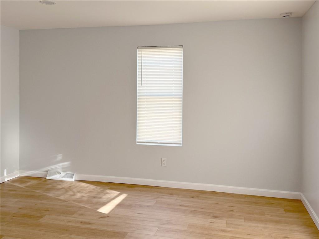 1252 Jefferson Street Vandergrift, PA 15690 - Photo 11 of 22 a view of an empty room with wooden floor and a window