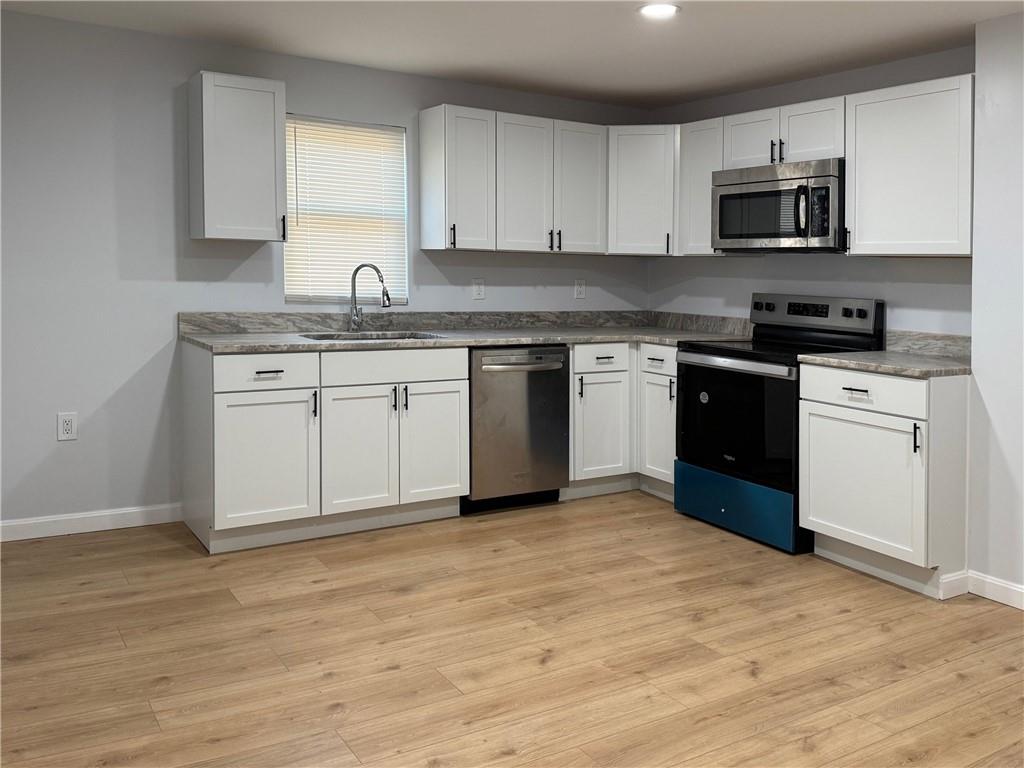 1252 Jefferson Street Vandergrift, PA 15690 - Photo 12 of 22 a kitchen with granite countertop a stove top oven sink and cabinets