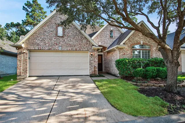 a front view of a house with a garden and trees