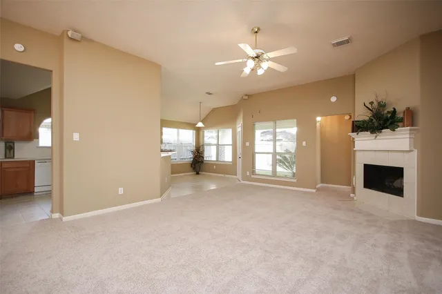 a view of a livingroom with a fireplace and chandelier fan
