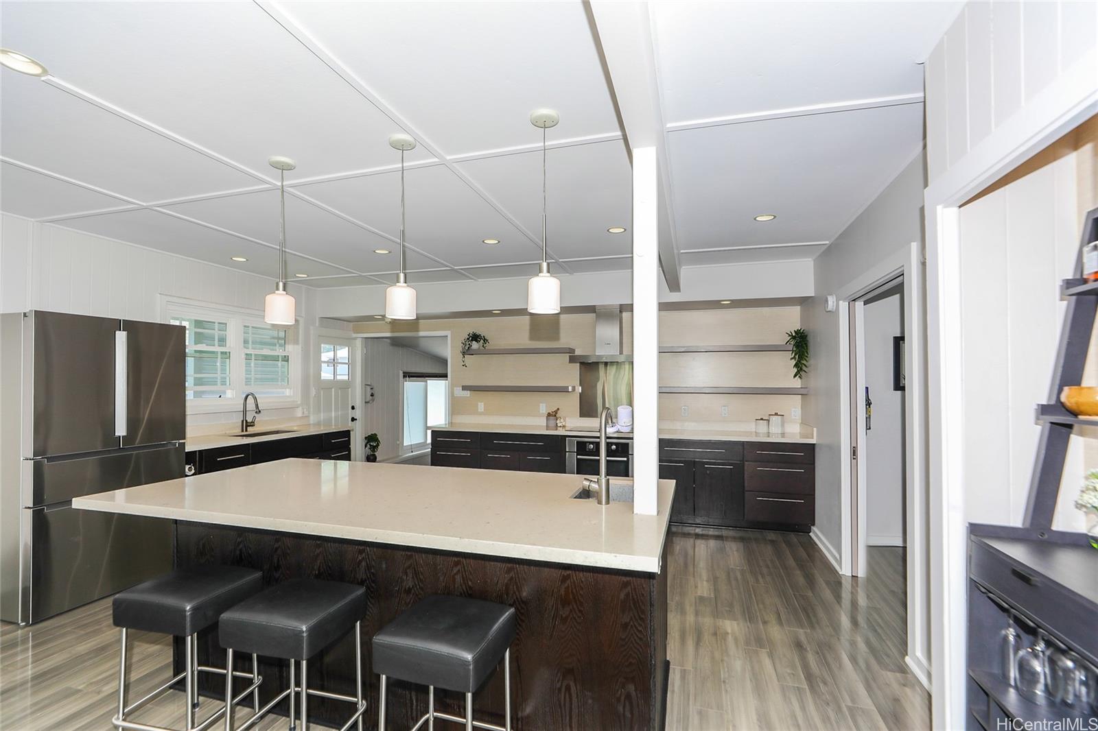 3305 East Manoa Road Honolulu, HI 96822 - Photo 7 of 25 a kitchen with stainless steel appliances a table chairs refrigerator and sink