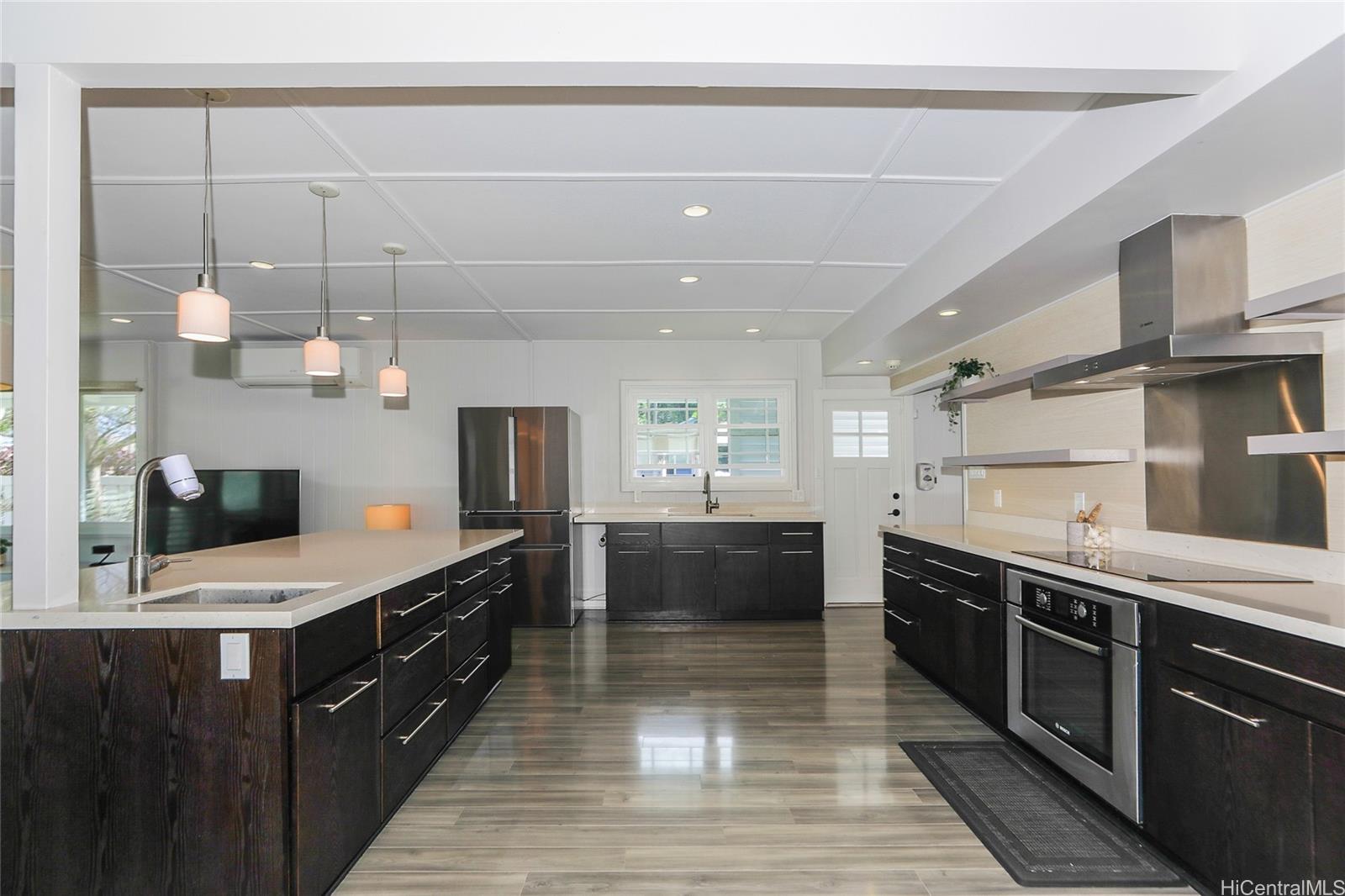 3305 East Manoa Road Honolulu, HI 96822 - Photo 8 of 25 a large kitchen with stainless steel appliances kitchen island granite countertop a sink counter space and cabinets