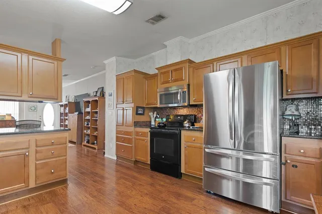a kitchen with stainless steel appliances a refrigerator stove and cabinets