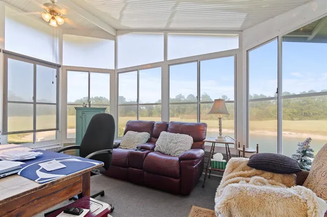 a living room with furniture and floor to ceiling windows