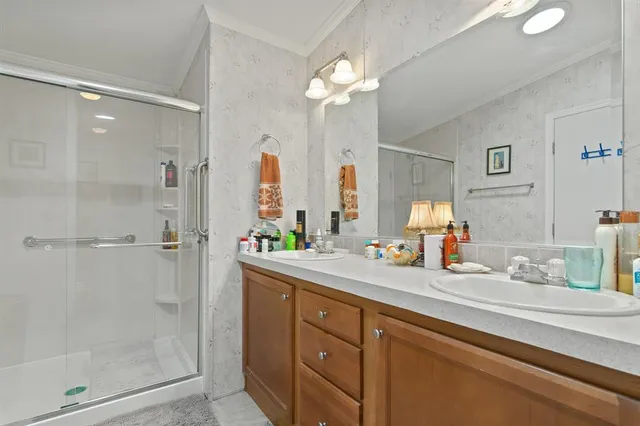 a bathroom with a double vanity sink mirror and shower